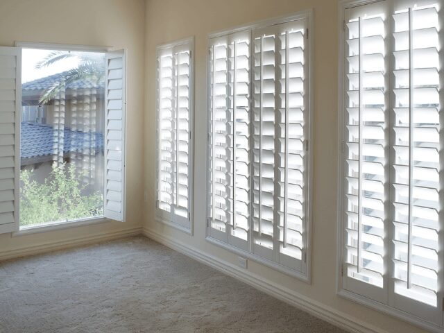 Plantation-Shutters-White-teak-Shutters-640x480 1 1 A room showcasing elegant white shutters.